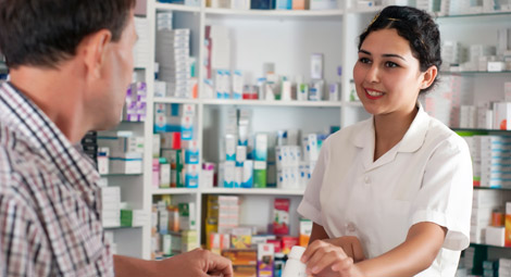Female pharmacist dispensing a prescription to a male client
